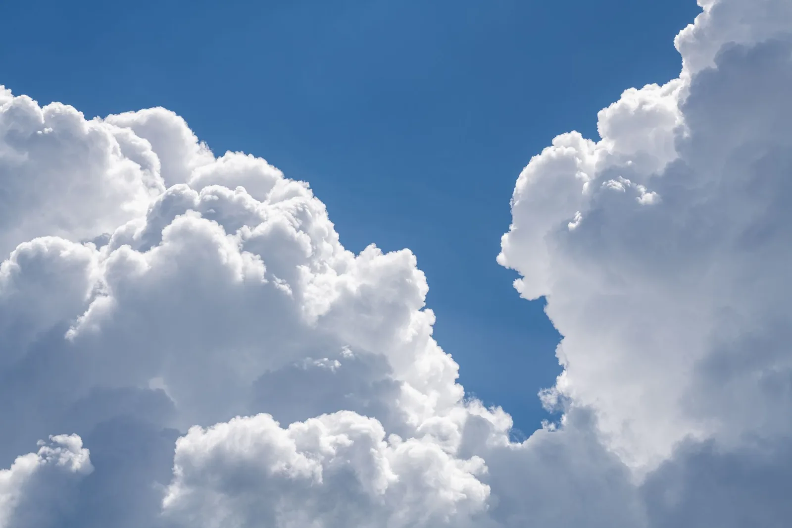 Beautiful cumulus clouds fill the summer sky, creating a serene and peaceful atmosphere.