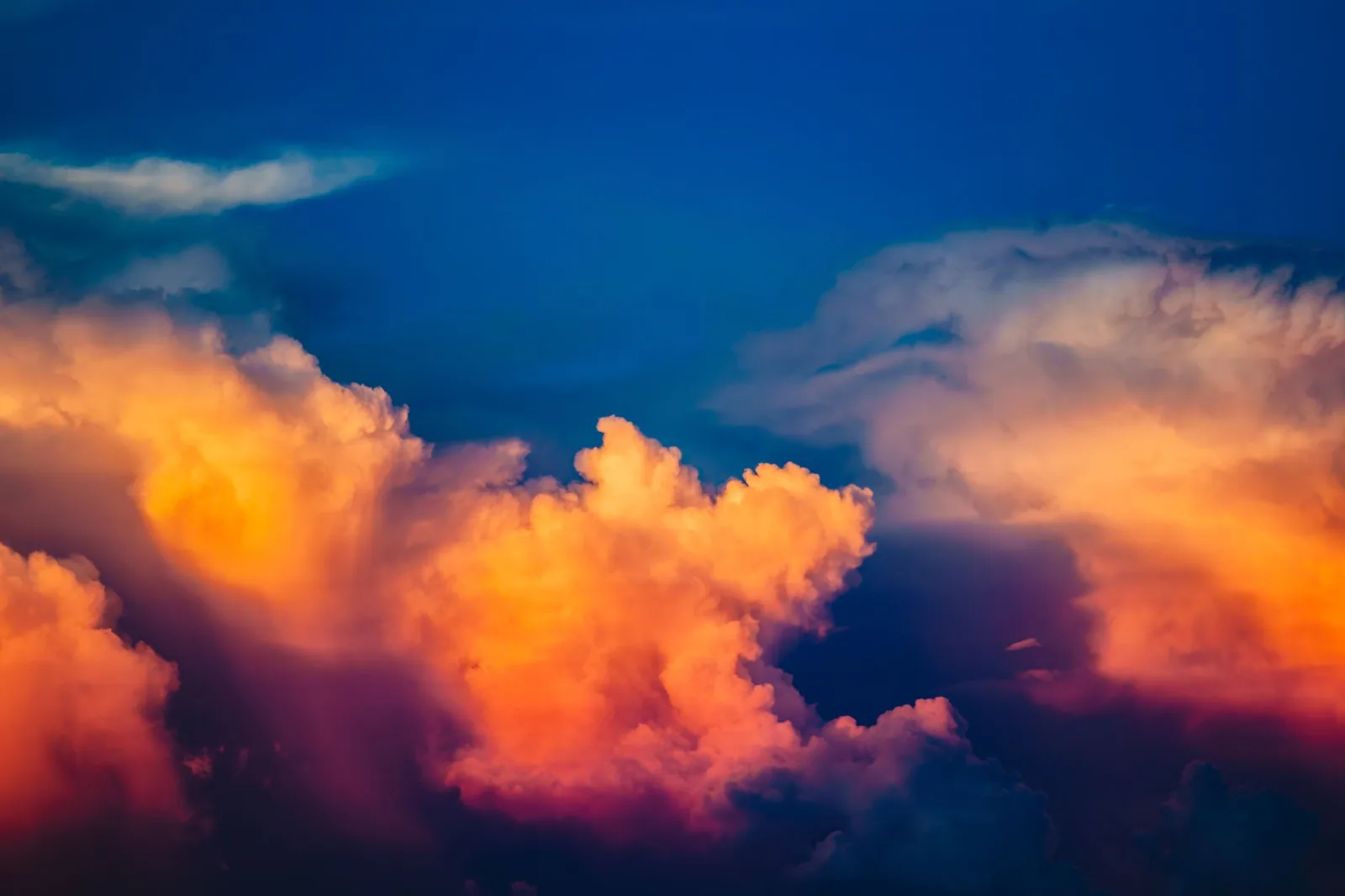 Vibrant clouds illuminated by a stunning sunset, showcasing vivid hues in a calm sky.