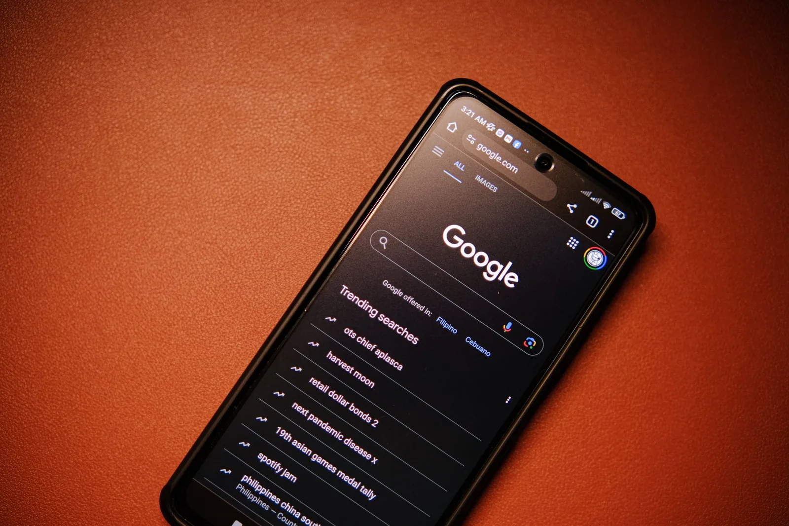 A smartphone displaying Google Search trends on a table at night.