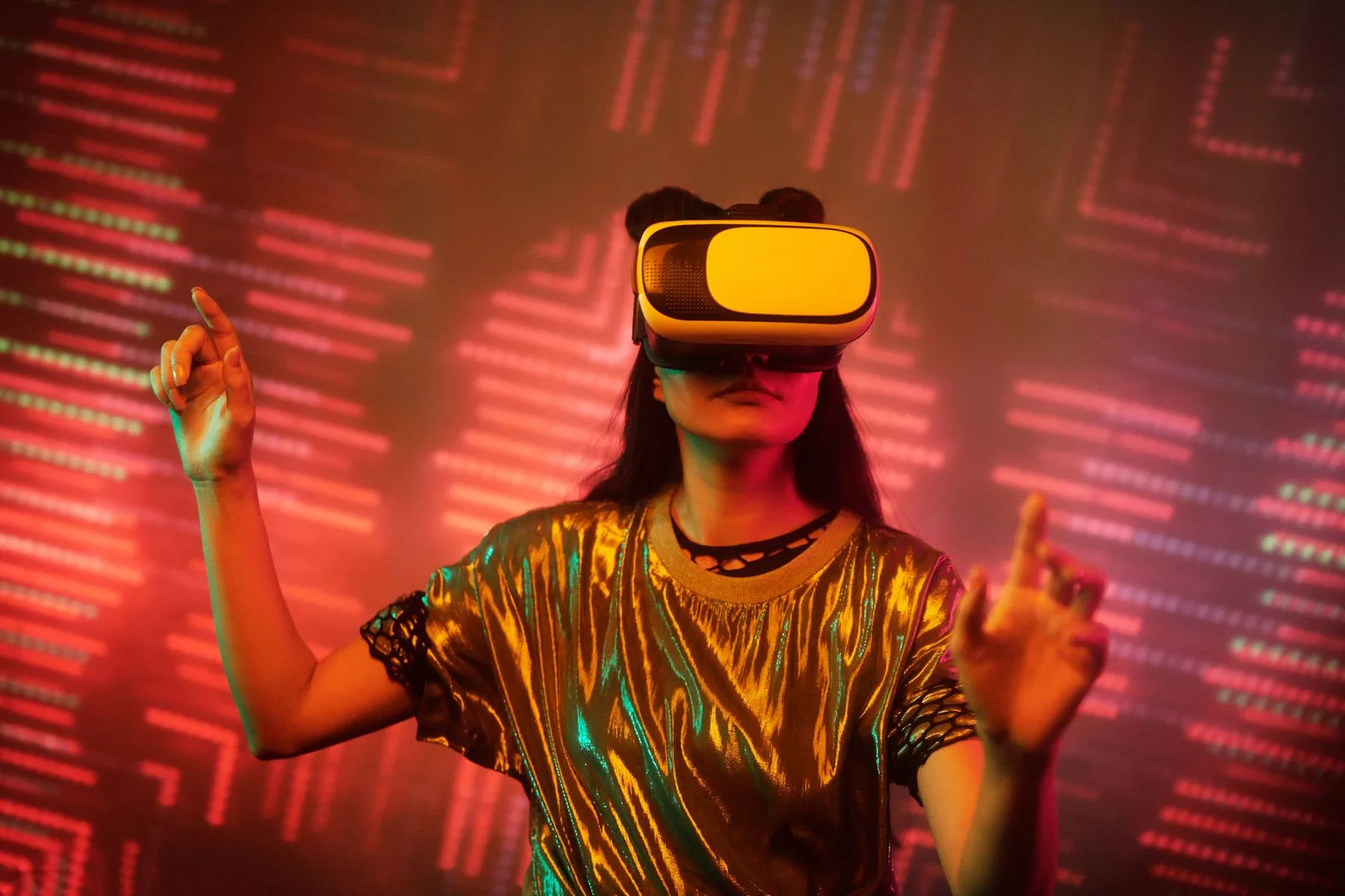 Woman in a metallic top using a virtual reality headset immersed in a digital environment with vibrant lights.