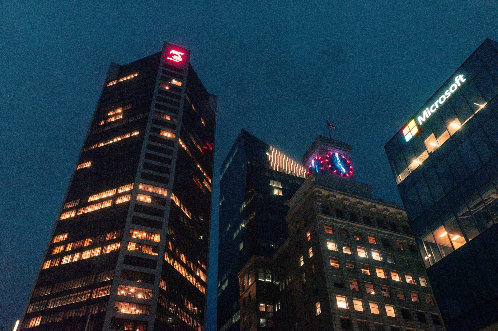 Vancouver skyline featuring illuminated skyscrapers at night with iconic architecture. Captured in British Columbia, Canada.