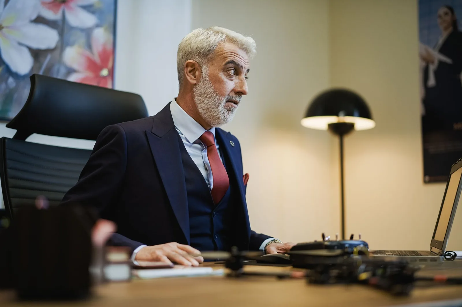 Senior businessman at his office desk, focused on work, with a stylish modern setup.